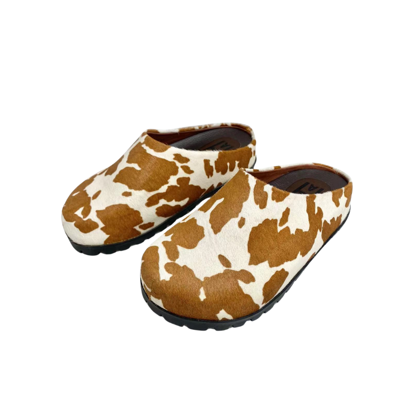Milky horsehair fashion clogs on white background with wooden platform