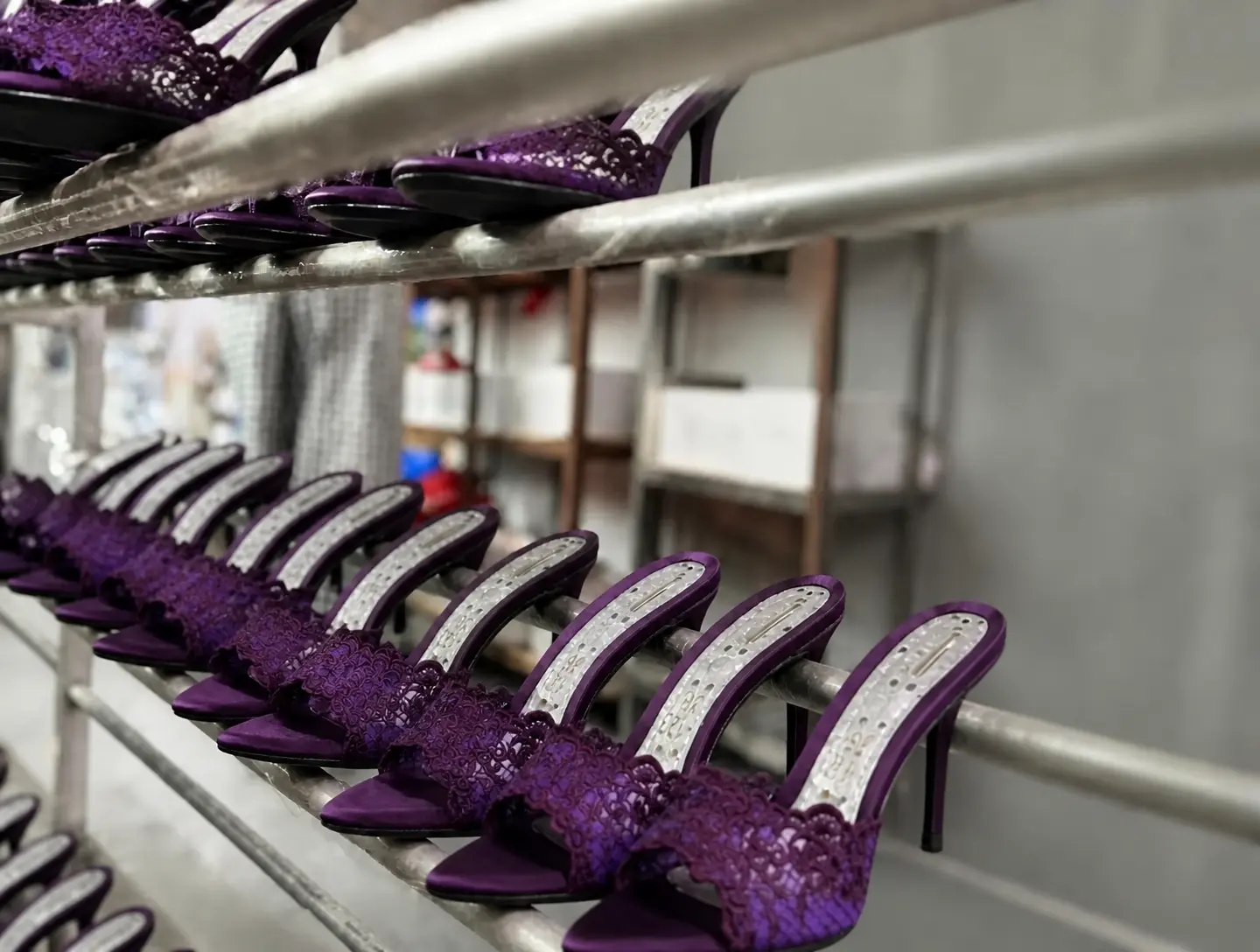 Bulk reorder of high-heeled sandals on the factory shelf — purple lace and gold sandals batch-stocked for restock, new colors and line extension